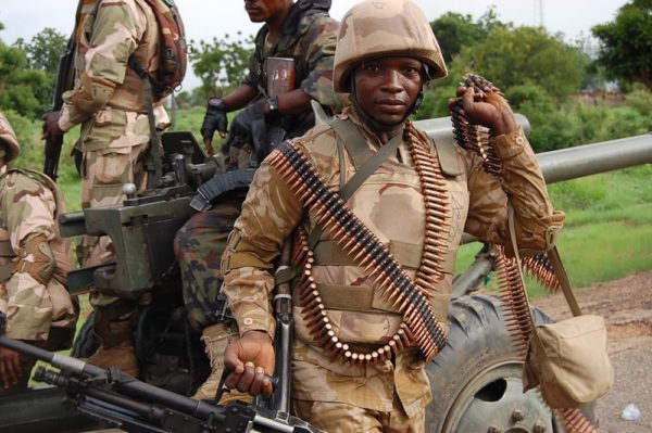 Nigerian troops in a TATA truck enter Damboa with a M56-2 howitzer trailing. Nigerian soldiers clustered around a M56-2 105mm artllery piece at Damboa - source - beegeagle.com