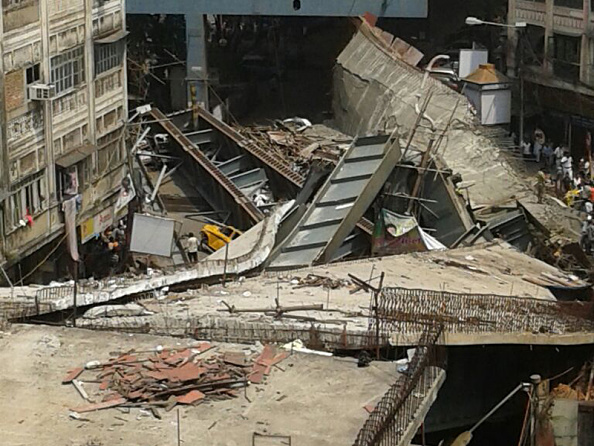 KOLKATA, INDIA - MARCH 31: (EDITORS NOTE: Image was created with a smartphone) A part of flyover collapsed on March 30, 2016 in Kolkata, India. At least two people were killed in Kolkata on Thursday and hundreds were feared trapped when an under-construction flyover collapsed onto traffic moving along the street below, police said. Fire-fighters and residents were trying to rescue those trapped under the wreckage of the metal-and-cement structure that came down near Girish Park in a teeming commercial district. (Photo by Hindustan Times)