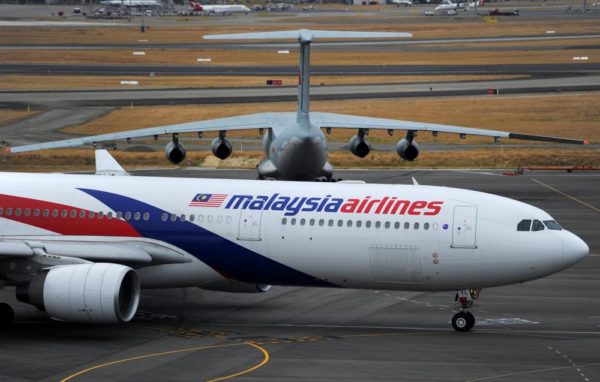 PERTH, AUSTRALIA - MARCH 25: A Malaysia Airlines plane prepares to go out onto the runway and passes by a stationary Chinese Ilyushin 76 aircraft (top) at Perth International Airport on March 25, 2014 in Perth Australia. The Australian Maritime Safety Authority has suspended the air and sea search for the missing Malaysian Airlines flight MH370 due to poor weather conditions in the search area. Search operations are expected to resume tomorrow. (Photo by Greg Wood - Pool/Getty Images)