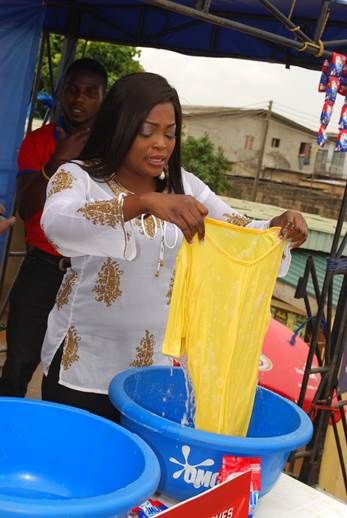 Funke Akindele demonstrating the fast action power of the New OMO Detergent