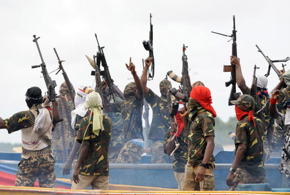 Fighters with the Movement for the Emancipation of the Niger Delta (MEND) raise their riffles to celebrate news of a successful operation by their colleagues against the Nigerian army in the Niger Delta on September 17, 2008. MEND has declared a full-scale "oil war" against the Nigerian authorities in response to attacks by the Nigerian military launched against the militants. "Our target is to crumble the oil installations in order to force the government to a round table to solve the problem once and for all", said Boy Loaf, leader of the militants. AFP PHOTO/PIUS UTOMI EKPEI (Photo credit should read PIUS UTOMI EKPEI/AFP/Getty Images)