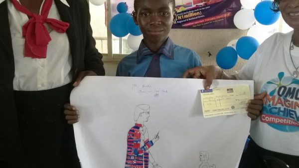 Christian Nwaegaruo, Nomadic Primary School, winner of the first position displaying his cheque of 70 thousand naira in the Imagine and Achieve Art Competition in Imo State