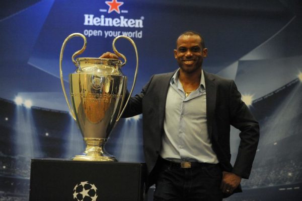 LAGOS, NIGERIA - MARCH 15: Former Nigerian international Sunday Oliseh poses with UEFA Trophy displayed for public viewing at Eko Hotel on March 15, 2014 in Lagos, Nigeria.  Football fans were given the opportunity to visit with the Heineken UEFA Champions League Trophy which began a three-nation tour in Nigeria under the auspices of Champions League partner, Heineken. Fans took photographs with the brand ambassador, former Real Madrid and ex-international football star Christian Karembeu. (Photo by Pius Utomi Ekpei/Getty Images)