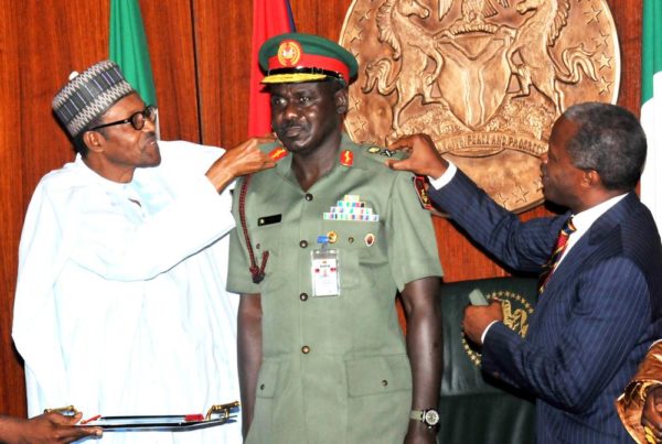 PIC 2. PRESIDENT MUHAMMADU BUHARI (L) AIDED BY VICE-PRESIDENT YEMI OSINBAJO IN DECORATING THE CHIEF OF ARMY STAFF, MAJ.-GEN. TUKUR BURATAI WITH HIS NEW RANK OF LT.-GEN, AT THE PRESIDENTIAL VILLA ABUJA ON THURSDAY (13/8/15). 5927/13/8/2015/ICE/CH/NAN