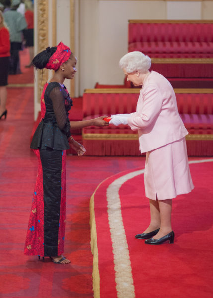 Nkechi receiving her award from the Queen of England