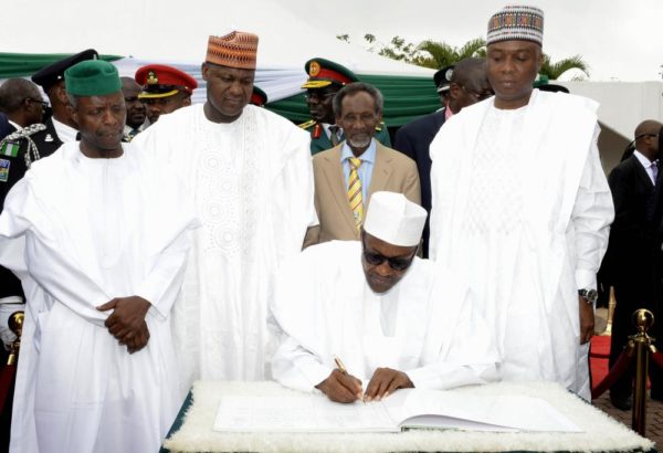 PIC. 2. STANDING FROM LEFT: VICE PRESIDENT YEMI OSINBAJO; SPEAKER HOUSE OF REPRESENTATIVES YAKUBU DOGARA; CHIEF JUSTICE OF NIGERIA, JUSTICE MAHMOUD MOHAMMED AND SENATE PRESIDENT BUKOLA SARAKI, WATCH PRESIDENT MUHAMMADU BUHARI, AS HE SIGNS THE REGISTER DURING THE PRESIDENTIAL CHANGE OF GUARDS TO MARK NIGERIAS  55TH INDEPENDENCE DAY CELEBRATION IN ABUJA ON THURSDAY (1/10/15). 6895/1/10/2015/ISE/ BJO/NAN