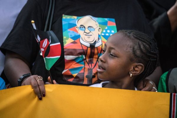 NAIROBI, KENYA - NOVEMBER 25: A young girl waits on the roadside for Pope Francis' convoy to drive through the capital from the airport on November 25, 2015 in Nairobi, Kenya. Pope Francis makes his first visit to Kenya on a five day African tour that is scheduled to include Uganda and the Central African Republic. Africa is recognised as being crucial to the future of the Catholic Church with the continent's Catholic numbers growing faster than anywhere else in the world. (Photo by Nichole Sobecki/Getty Images)