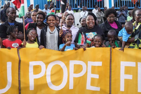 NAIROBI, KENYA - NOVEMBER 25: Crowds of people gather on the roadside as Pope Francis' convoy drives through the capital from the airport on November 25, 2015 in Nairobi, Kenya. Pope Francis makes his first visit to Kenya on a five day African tour that is scheduled to include Uganda and the Central African Republic. Africa is recognised as being crucial to the future of the Catholic Church with the continent's Catholic numbers growing faster than anywhere else in the world. (Photo by Nichole Sobecki/Getty Images)