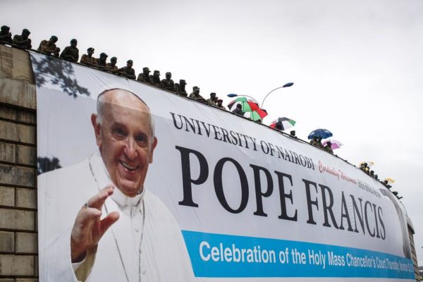 NAIROBI, KENYA - NOVEMBER 26: Security gathers on an overpass above the University of Nairobi grounds on November 26, 2015, to watch a mass delivered by Pope Francis in Nairobi, Kenya. Pope Francis makes his first visit to Kenya on a five day African tour that is scheduled to include Uganda and the Central African Republic. Africa is recognised as being crucial to the future of the Catholic Church with the continent's Catholic numbers growing faster than anywhere else in the world. (Photo by Nichole Sobecki/Getty Images)