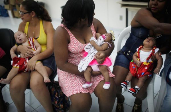 Babies dressed in Carnival outfits, born with microcephaly, are held by their mothers at a Carnival party held for babies with the condition in a health clinic on February 4, 2016 in Recife, Pernambuco state, Brazil. The mosquito-borne Zika virus may have led to microcephaly in infants in Brazil.  (Photo by Mario Tama/Getty Images)