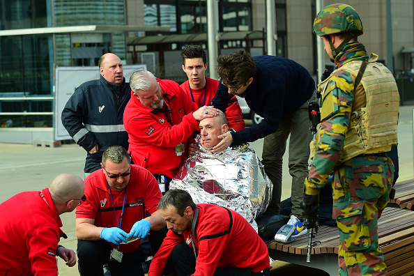 A victim receives first aid by rescuers, on March 22, 2016 near Maalbeek metro station in Brussels, after a blast at this station near the EU institutions caused deaths and injuries. AFP PHOTO / EMMANUEL DUNAND / AFP / EMMANUEL DUNAND (Photo credit should read EMMANUEL DUNAND/AFP/Getty Images)