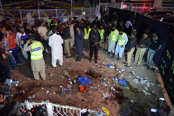 Pakistani rescuers and officials gather at a bomb blast site in Lahore on March 27, 2016. At least 25 people were killed and dozens injured when an explosion ripped through the parking lot of a crowded park where many minority Christians had gone to celebrate Easter Sunday in the Pakistani city Lahore, officials said. / AFP / ARIF ALI (Photo credit should read ARIF ALI/AFP/Getty Images)