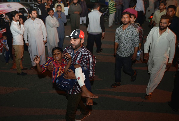 A Pakistani relative carries an injured child to the hospital in Lahore on March 27, 2016, after at least 56 people were killed and more than 200 injured when an apparent suicide bomb ripped through the parking lot of a crowded park in the Pakistani city of Lahore where Christians were celebrating Easter. / AFP / ARIF ALI (Photo credit should read ARIF ALI/AFP/Getty Images)
