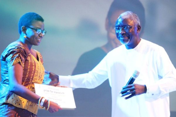 Patron of the Etisalat Prize for Literature, Dele Olojede presenting the prize to the winner of the 2014 Etisalat Prize for Literature Flash Fiction Category, Neema Komba