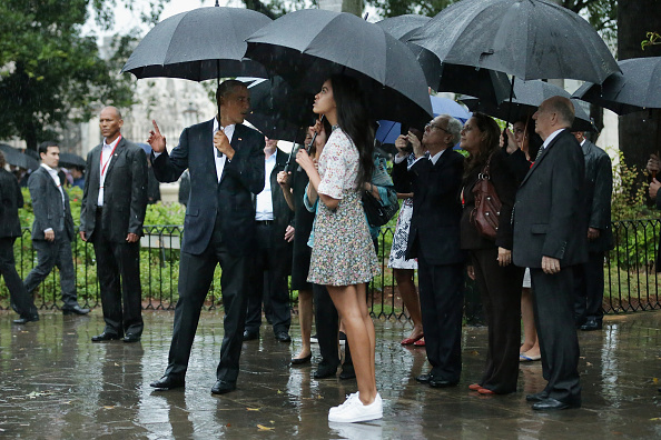 HAVANA, CUBA - MARCH 20: Taking shelter from the pouring rain under umbrellas, U.S. President Barack Obama, his daughter Malia, 17, and members of the first family take a walking tour of in the plaza of the 18th century Catedral de San Cristobal de la Habana in the historic Old Havana neighborhood March 20, 2016 in Havana, Cuba. Obama is the first sitting president to visit Cuba in nearly 90 years. (Photo by Chip Somodevilla/Getty Images)