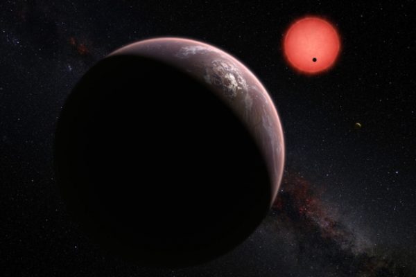 This artist’s rendering shows an imagined view of the three planets orbiting an ultracool dwarf star just 40 light-years from Earth that were discovered using the TRAPPIST telescope at ESO’s La Silla Observatory. In this view, one of the inner planets is seen in transit across the disc of its tiny and dim parent star. Image: M. Kornmesser/ESO via MIT News