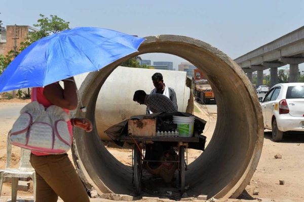 An Indian roadside food vendor sets up his cart inside a concrete pipe in Gurgaon on the outskirts of New Delhi on May 27, 2015. IMAGE: CHANDAN KHANNA/AFP/GETTY IMAGES