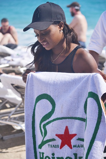 Anita Brows enjoying the beach with customized Heineken towels