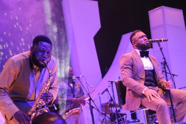 Mike Aremu and Praiz performing on stage