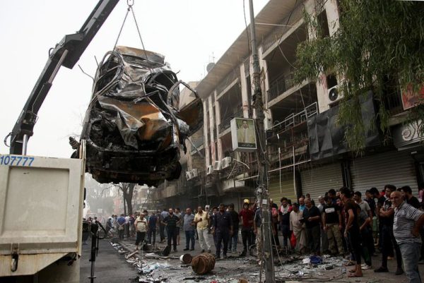 BAGHDAD, IRAQ - JULY 03: Damaged car is lifted after a suicide car bombing, claimed by the terrorist organization DAESH, in the Karrada neighborhood of Baghdad, Iraq on July 03, 2016. It is reported that 60 people were killed and 100 wounded in the blast. (Photo by Amir Saadi/Anadolu Agency/Getty Images)