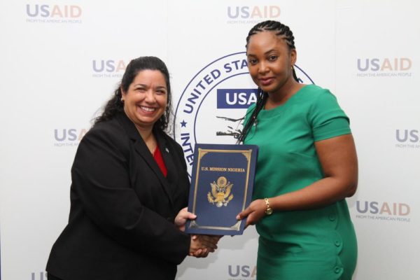 DCM, Maria E. Brewer presents Chinwe Osuji of Babban Gona with signed agreements