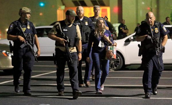 DALLAS, TX - JULY 8:  Dallas police escort a woman near the scene where four Dallas police officers were shot and killed on July 7, 2016 in Dallas, Texas. According to reports, shots were fired during a protest being held in downtown Dallas in response to recent fatal shootings of two black men by police - Alton Sterling on July 5, 2016 in Baton Rouge, Louisiana and Philando Castile on July 6, 2016, in Falcon Heights, Minnesota. (Photo by Ron Jenkins/Getty Images)