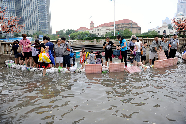 TIANJIN, CHINA - JULY 20: Citizens protect subway station from floodwater on July 20, 2016 in Tianjin, China. Tianjin Meteorological Observatory has issued an orange alert to heavy rainfall at 08:07 am early Wednesday and the rainstorm is predicted to continue in following six hours. (Photo by VCG/VCG via Getty Images)