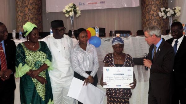 USAID MD Mike Harvey (2nd right) presenting a cash voucher to one of the beneficiaries of a cash transfer program to assist HIVAIDS affected children and families in Edo State. (1) - Copy