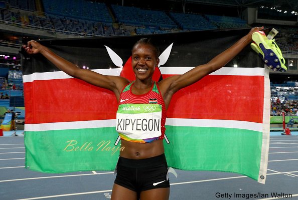 RIO DE JANEIRO, BRAZIL - AUGUST 16: Faith Chepngetich Kipyegon of Kenya celebrates with the flag of Kenya after winning the gold medal in the Women's 1500m Final on Day 11 of the Rio 2016 Olympic Games at the Olympic Stadium on August 16, 2016 in Rio de Janeiro, Brazil. (Photo by Ian Walton/Getty Images)