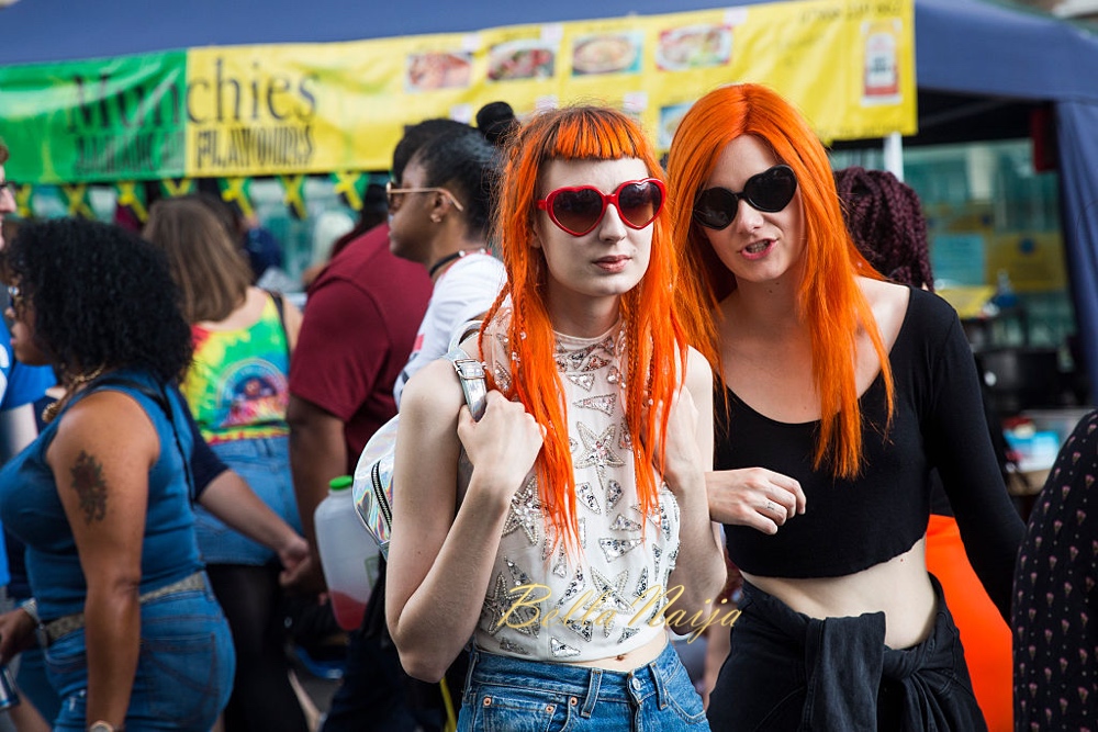 LONDON, ENGLAND - AUGUST 29: Two women with orange hair walk through Notting Hill Carnival on August 29, 2016 in London, England. The Notting Hill Carnival, which has taken place annually since 1964, is expected to attract over a million people. The two-day event, started by members of the Afro-Caribbean community, sees costumed performers take to the streets in a parade and dozens of sound systems set up around the Notting Hill streets. (Photo by Jack Taylor/Getty Images)