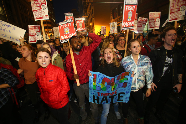 SEATTLE, WA - NOVEMBER 09: (EDITORS NOTE: Image contains profanity) Emma Esselstyn (C) a student from the University of Washington, join thousands of protesters march down 2nd Avenue on November 9, 2016 in Seattle, Washington. Demostrations in multiple cities around the country were held the day following Donald Trump's upset win in last night's U.S. presidential election. (Photo by Karen Ducey/Getty Images)