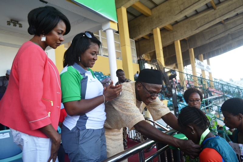 L-R: Heritage Bank-Lagos State Skoolimpics Brand Ambassador, Mary Onyali; Executive Director, Heritage Bank, Mary Akpobome and the Minister of Sports and Youth Development, Mr. Solomon Dalung decorating a winner with a medal at the closing ceremony of the pilot edition of the bank's signature sporting event, Skoolimpics