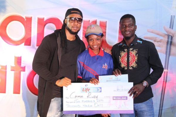 Flavour brand ambassador for Life Continental Beer, and Akinola Josiah Olufemi, Assistant Brand Manager, Regional Mainstream Brands, NB Plc presenting a cheque of N250, 000 to Chima Ruby, one of the winners of the Life Progress Booster Show in Onitsha.