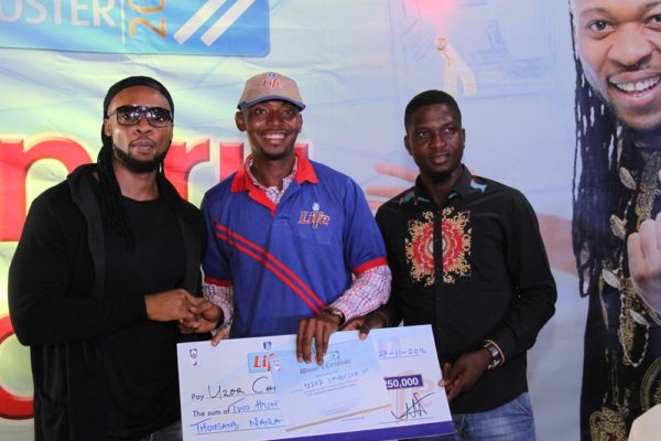 Flavour, brand ambassador for Life Continental Beer, and Akinola Josiah Olufemi, Assistant Brand Manager, Regional Mainstream Brands, NB Plc presenting a cheque of N250, 000 to Uzor Chibuzor, one of the winners of the Life Progress Booster Show in Onitsha.