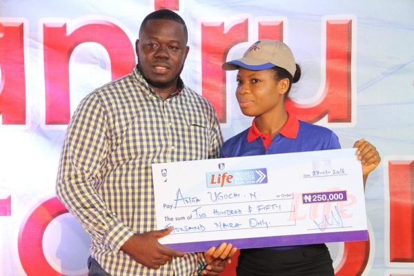 Kelvin Aladesanmi, Sales Executive, Onitsha, NB Plc presenting a cheque of N250,000 to Anita Ugochi, one of the winners of the Life Progress Booster Show in Onitsha.