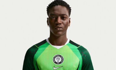 A male model wearing the 2026 Nike Super Eagles home jersey in a vibrant lemon green with dark green armour-style side panels.