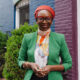 A professional portrait of Nabila Aguele, the first Nigeria-based Global CEO of Malala Fund, wearing a green blazer and red headwrap.
