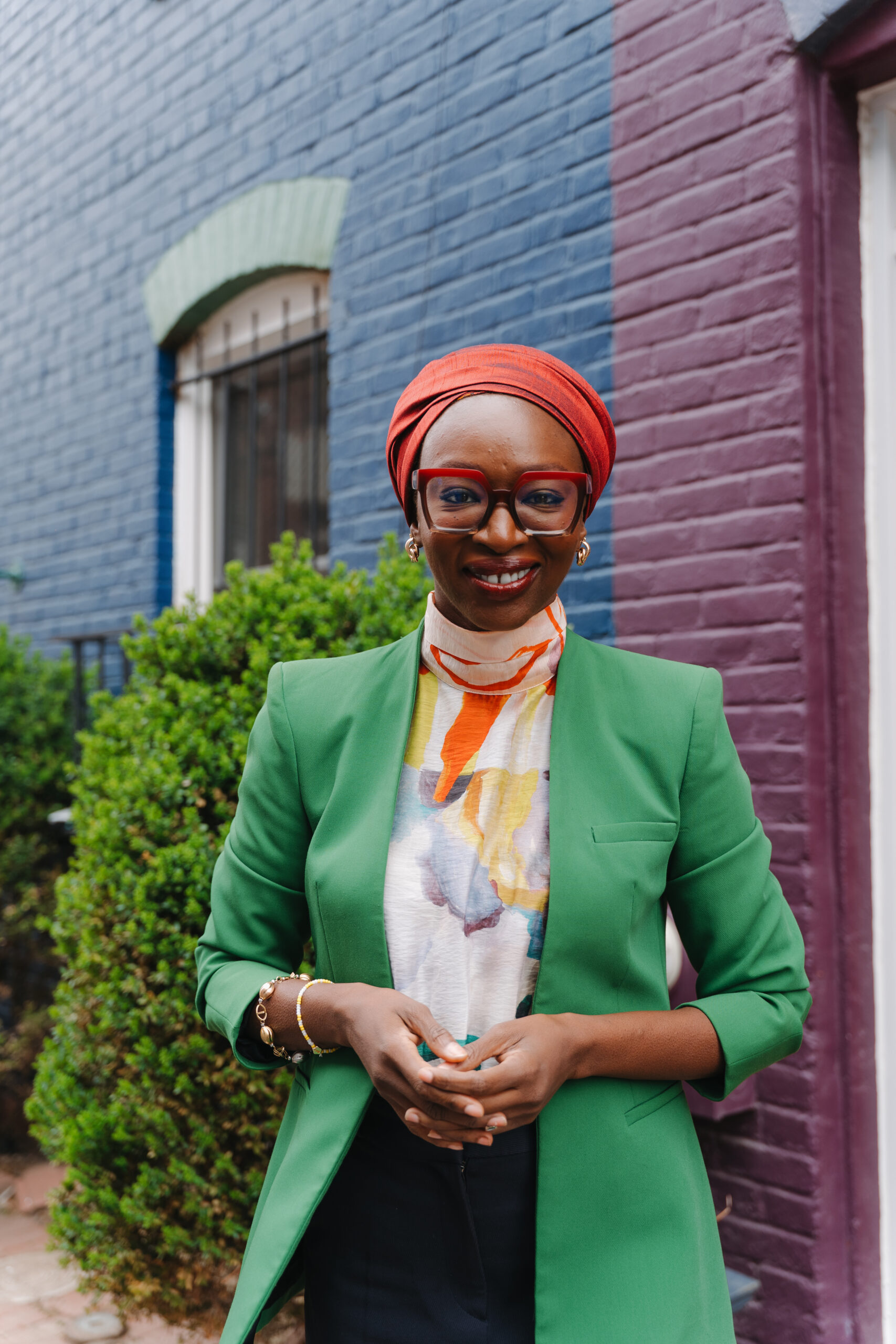 A professional portrait of Nabila Aguele, the first Nigeria-based Global CEO of Malala Fund, wearing a green blazer and red headwrap.