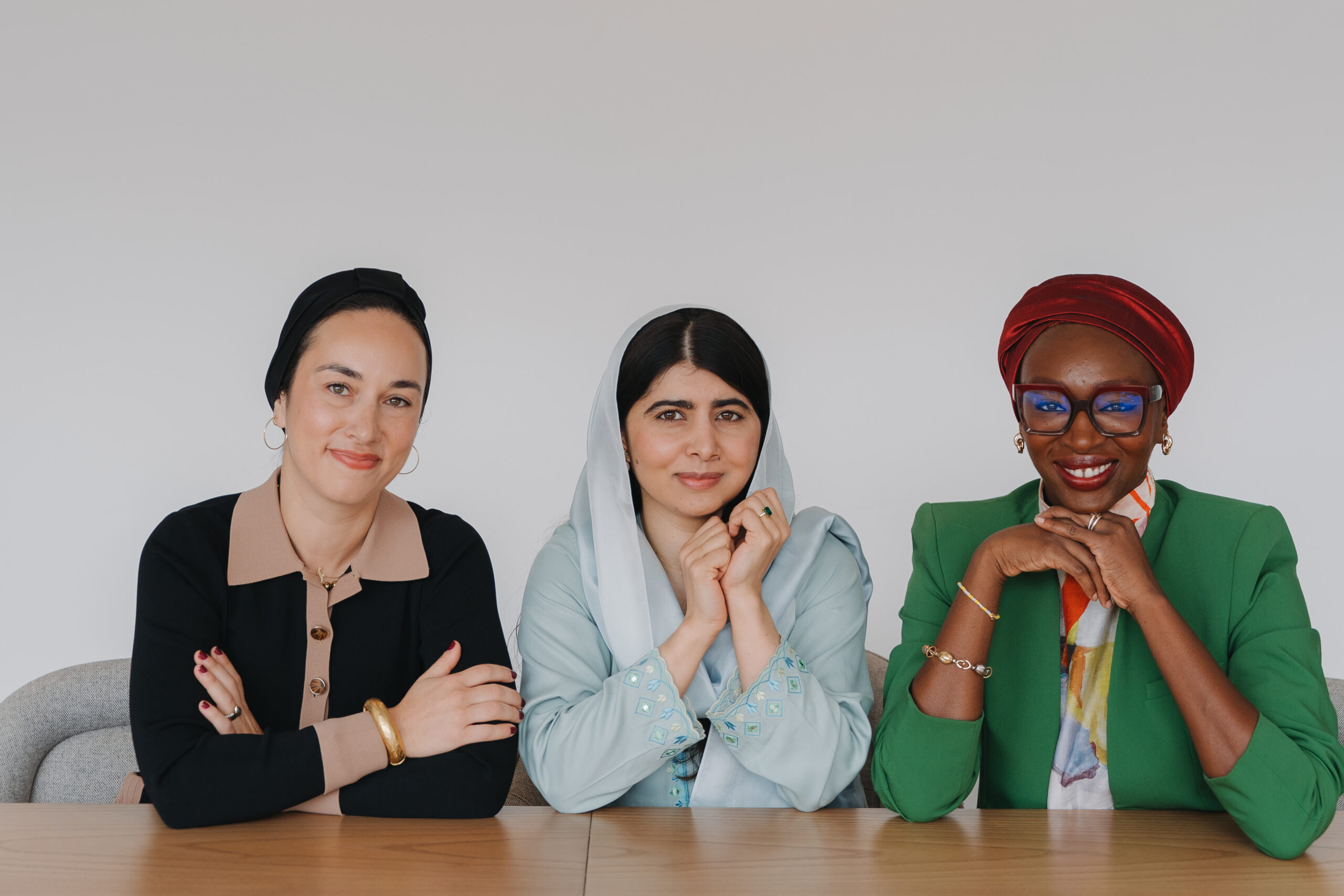 From left to right: Outgoing CEO Lena Alfi, Co-founder Malala Yousafzai, and incoming CEO Nabila Aguele seated together at a table.