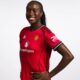 Official studio portrait of Simi Awujo, Manchester United Women’s midfielder. She is smiling, with her hair in neat braids, wearing the 2025/26 red home kit featuring the Snapdragon sponsor logo.