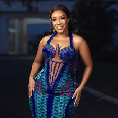 Joselyn Dumas wearing a floor-length Kente dress with blue velvet accents and a beaded fringe bodice for Ghana's 69th Independence Day in March 2026.