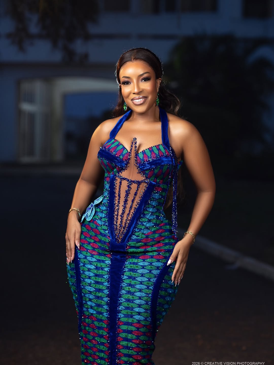 Joselyn Dumas wearing a floor-length Kente dress with blue velvet accents and a beaded fringe bodice for Ghana's 69th Independence Day in March 2026.