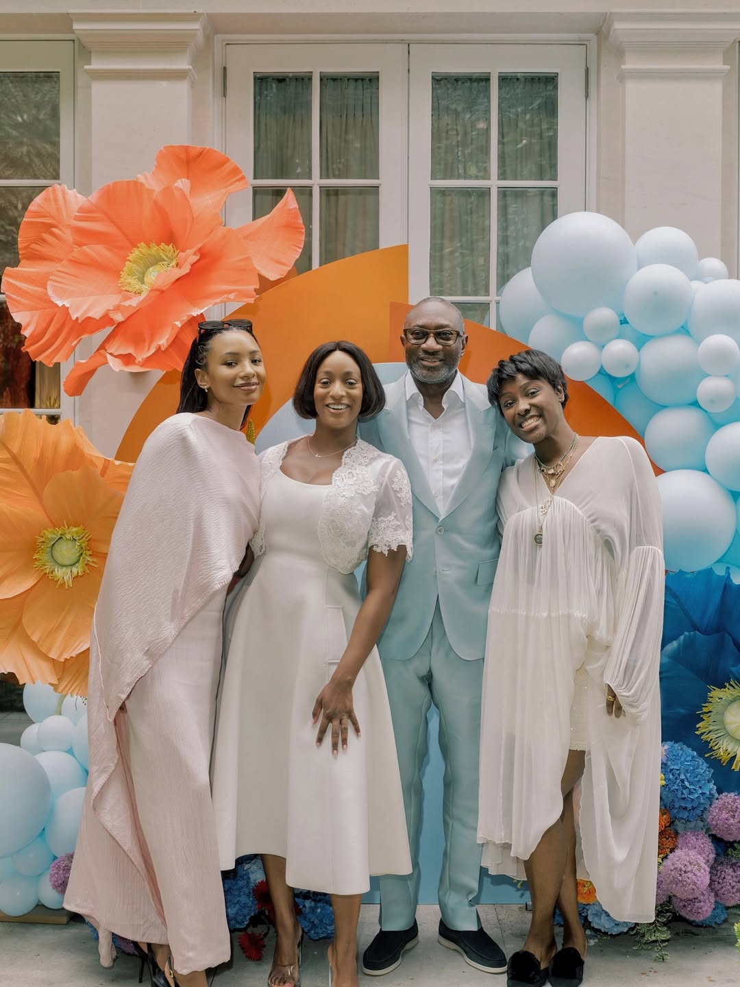 Femi Otedola with his daughters Cuppy, Temi Ajibade, and Tolani Otedola in coordinated white and cream outfits for International Women's Day 2026.