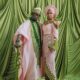 Simi Sanya and Femi Dapson posing for their first look at their traditional wedding in blush pink and forest green outfits.
