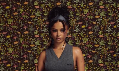 Tyla at the Miu Miu Fall/Winter 2026 show in Paris wearing a grey open-side knit vest and low-slung blue jeans that reveal the logo waistband of grey Miu Miu briefs.