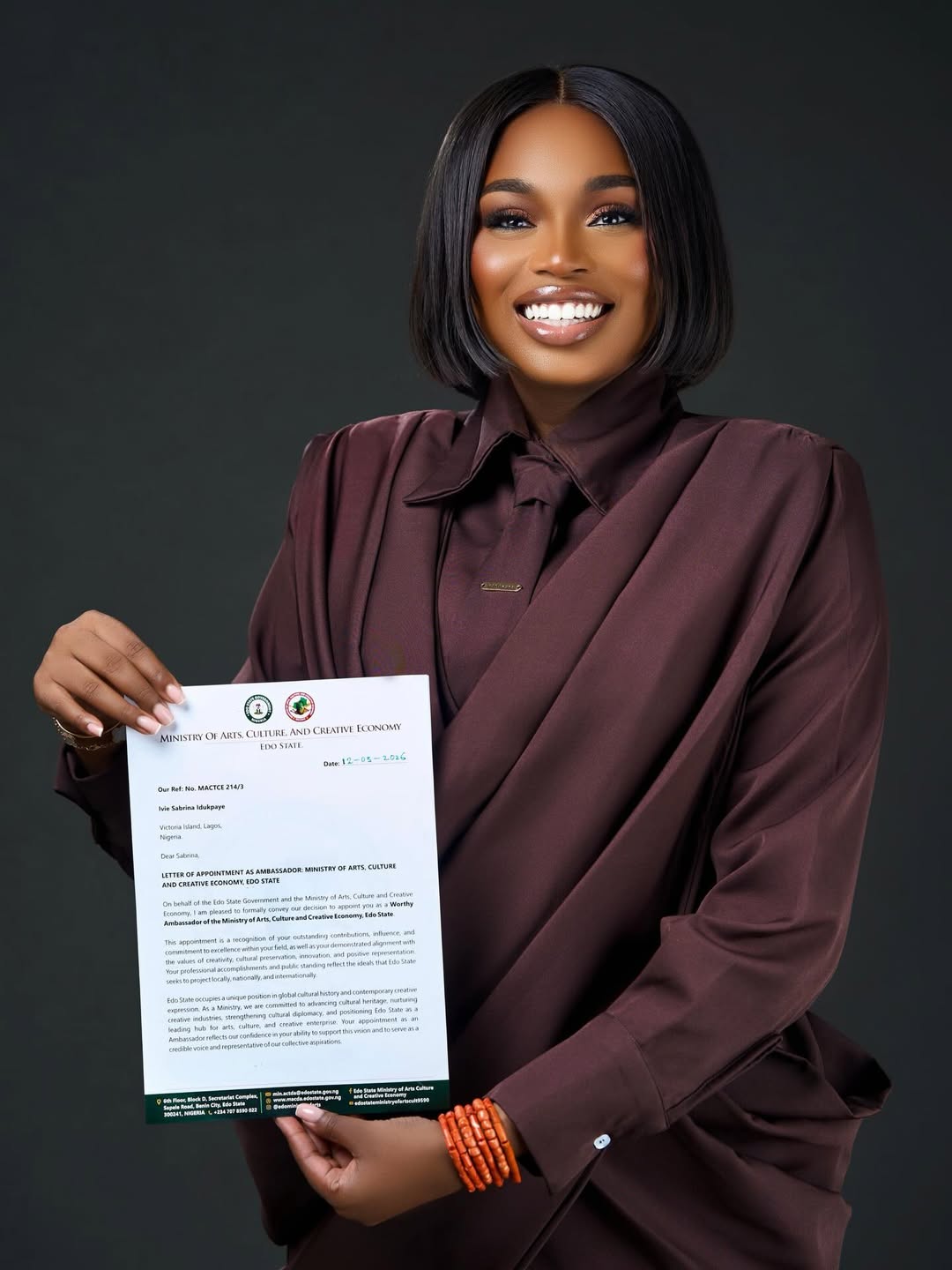 Sabrina Idukpaye holding her official letter from the Edo State Ministry of Arts and Culture.