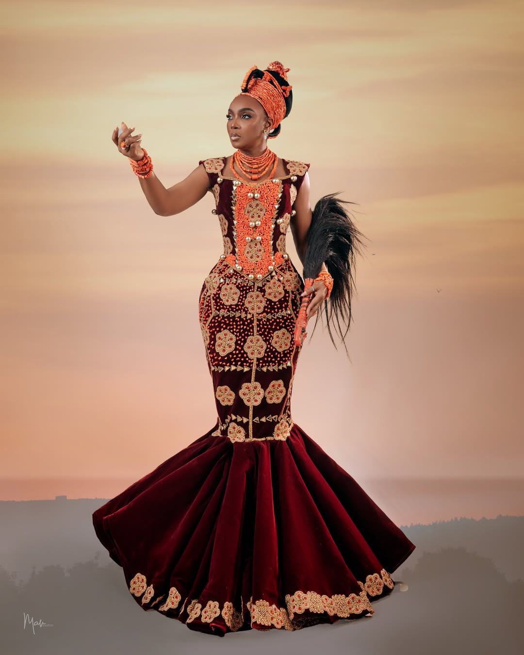 Chioma Akpotha in a wine-coloured gown with gold floral embroidery, tiered coral beads, and a traditional Okuku crown for her birthday.