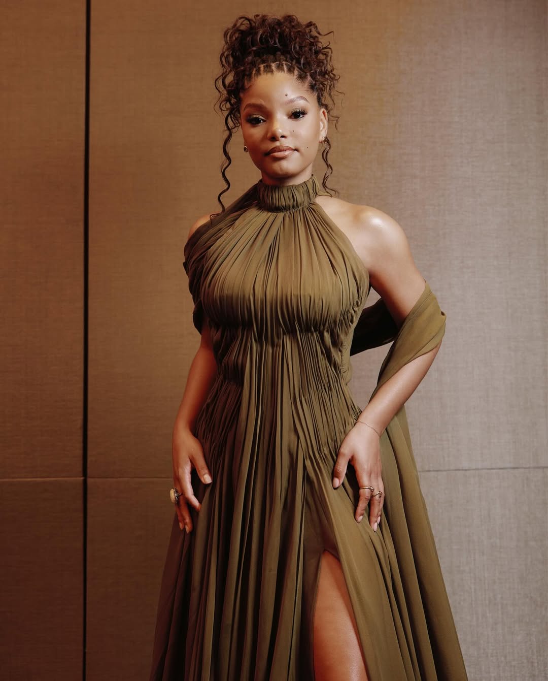 Halle Bailey in a moss-green pleated chiffon gown at the Fairmont Century Plaza.