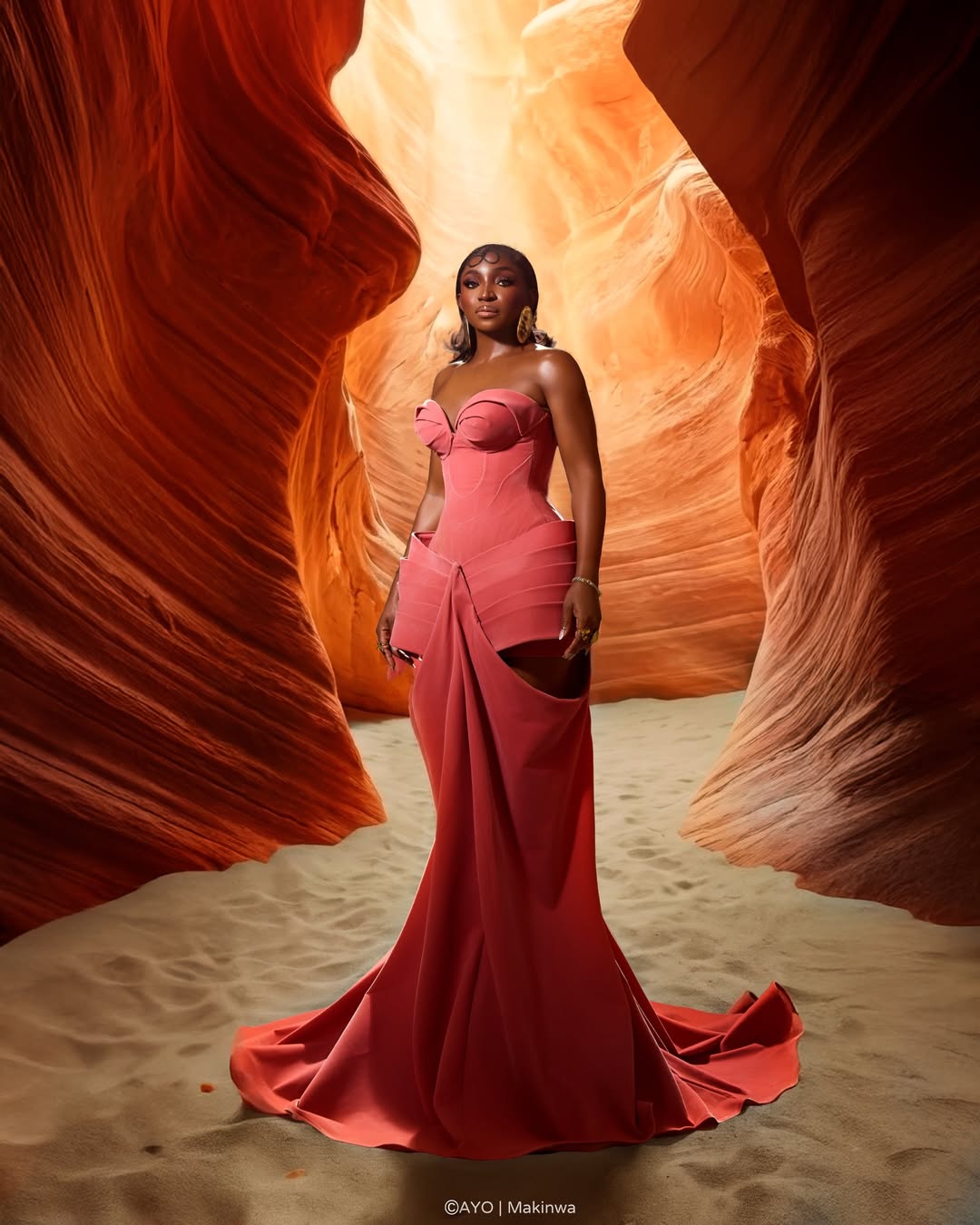 Omowunmi Dada in a coral pink strapless structured gown with a sculptural bow and architectural corseted bodice at the Evi premiere.