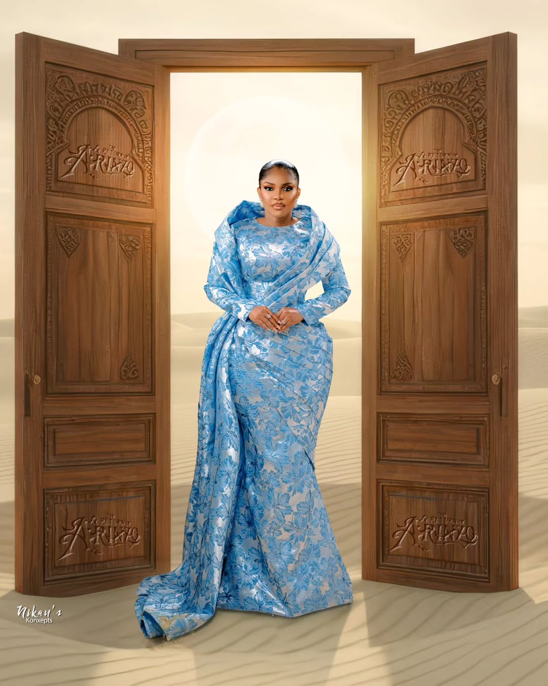 Iyabo Ojo at The Return of Arinzo premiere in a blue floral jacquard mermaid gown with a dramatic floor-length draped overlay.